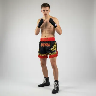 Custom Muay Thai shorts in black satin with gold shine trim and red fringe