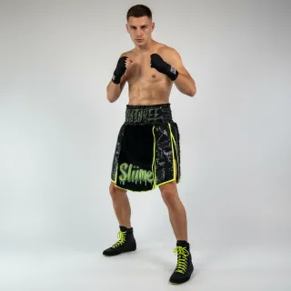 Custom gladiator boxing shorts side view in black long fur with neon satin trim and Warrior design