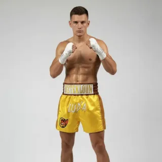 Custom Muay Thai shorts in yellow gold shimmer satin with embroidered names and logos